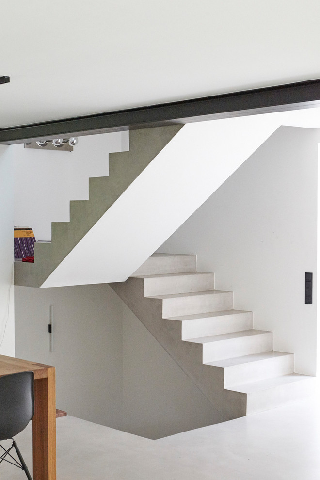 На фото: бетонная лестница на больцах, среднего размера в стиле модернизм с бетонными ступенями и стеклянными перилами