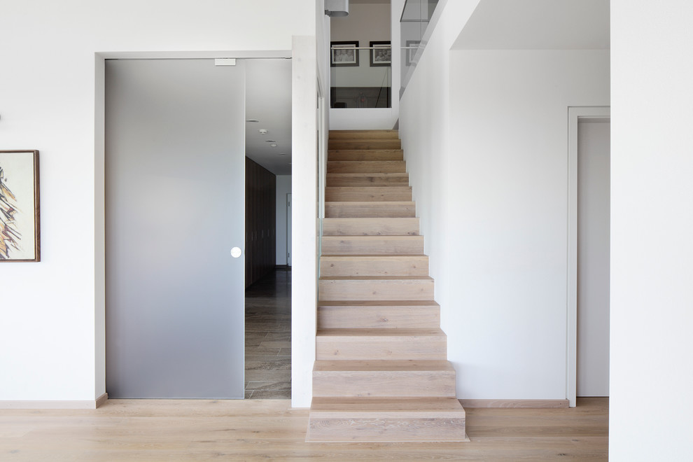 Свежая идея для дизайна: прямая деревянная лестница среднего размера в стиле модернизм с деревянными ступенями - отличное фото интерьера