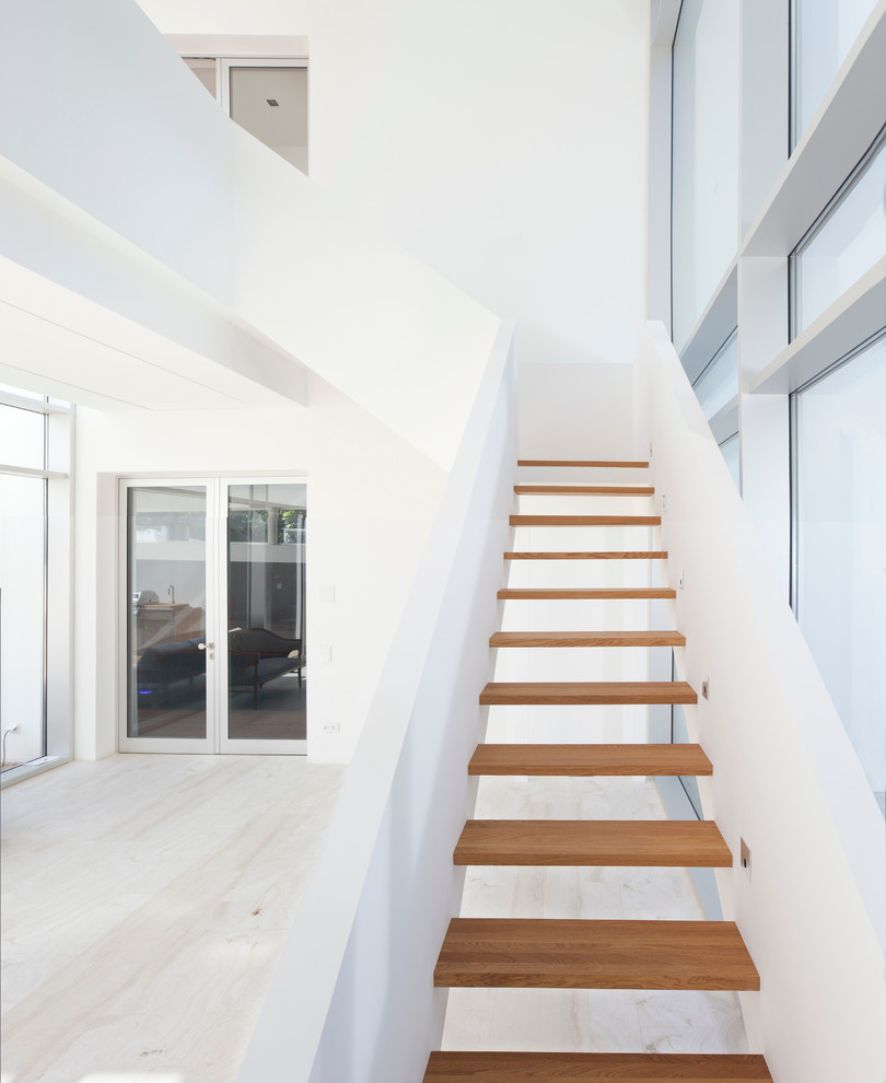 Foto de escalera en L contemporánea de tamaño medio sin contrahuella con escalones de madera
