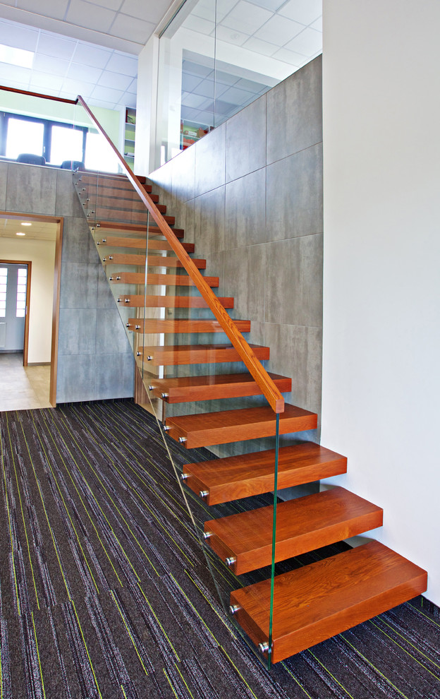Diseño de escalera suspendida moderna grande sin contrahuella con escalones de madera