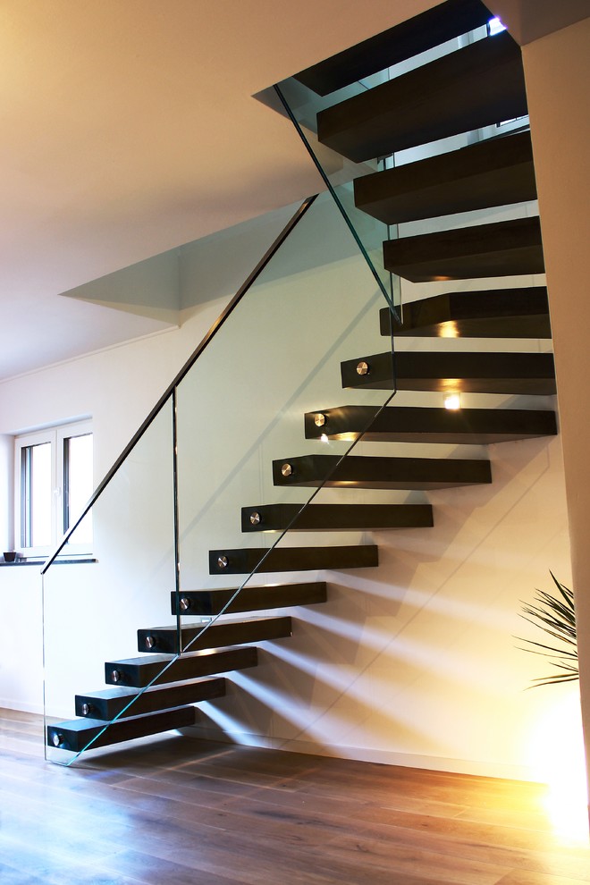 Cette photo montre un grand escalier flottant moderne avec des marches en bois, des contremarches en bois et éclairage.