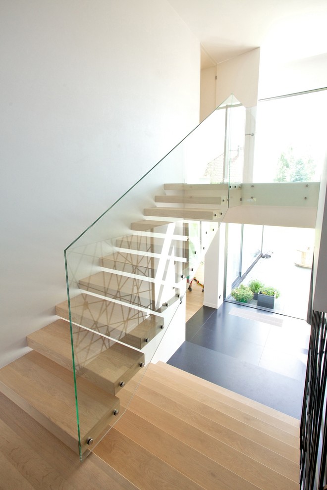 Inspiration for a large modern wood floating staircase in Other with open risers.