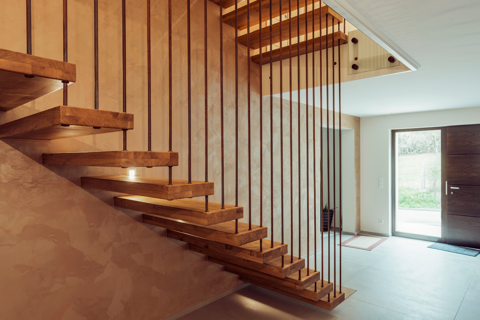 На фото: большая угловая лестница в стиле лофт с деревянными ступенями и перилами из смешанных материалов