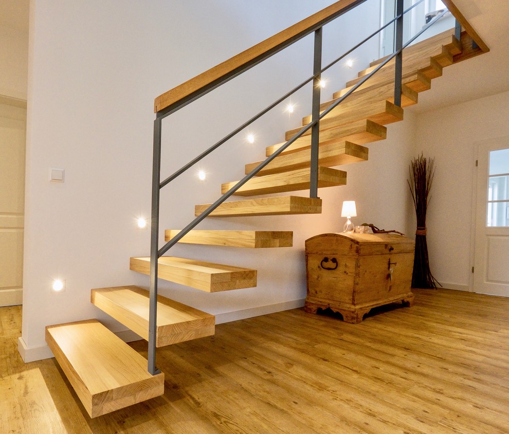 На фото: прямая лестница среднего размера в современном стиле с деревянными ступенями и перилами из смешанных материалов без подступенок