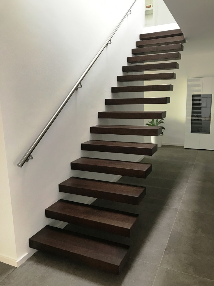 Ejemplo de escalera suspendida moderna grande sin contrahuella con escalones de madera