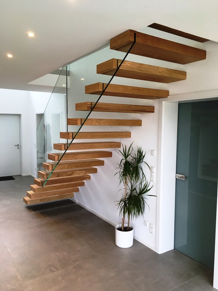 Aménagement d'un grand escalier sans contremarche flottant moderne avec des marches en bois.