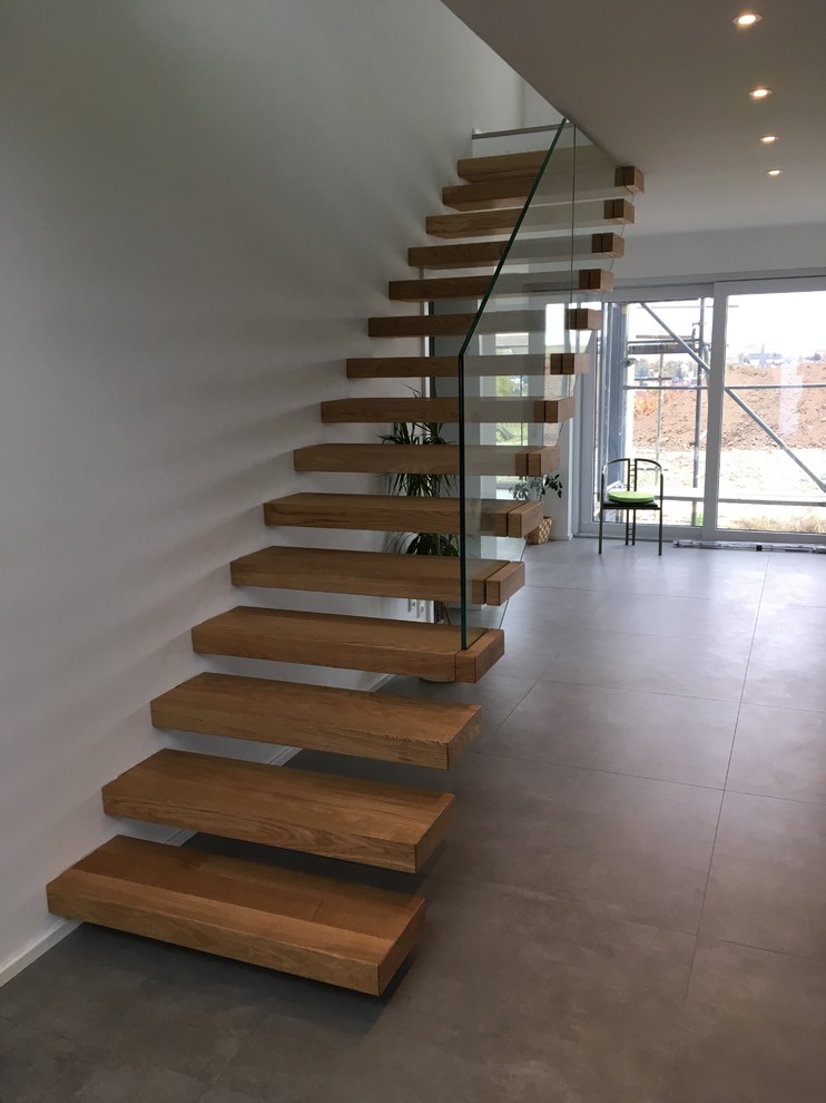 Design ideas for a large modern wood floating staircase in Other with open risers.