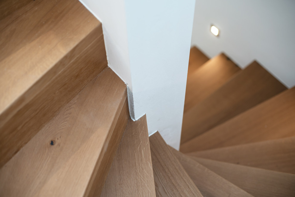 Gewendelte, Mittelgroße Moderne Holztreppe mit Holz-Setzstufen in München