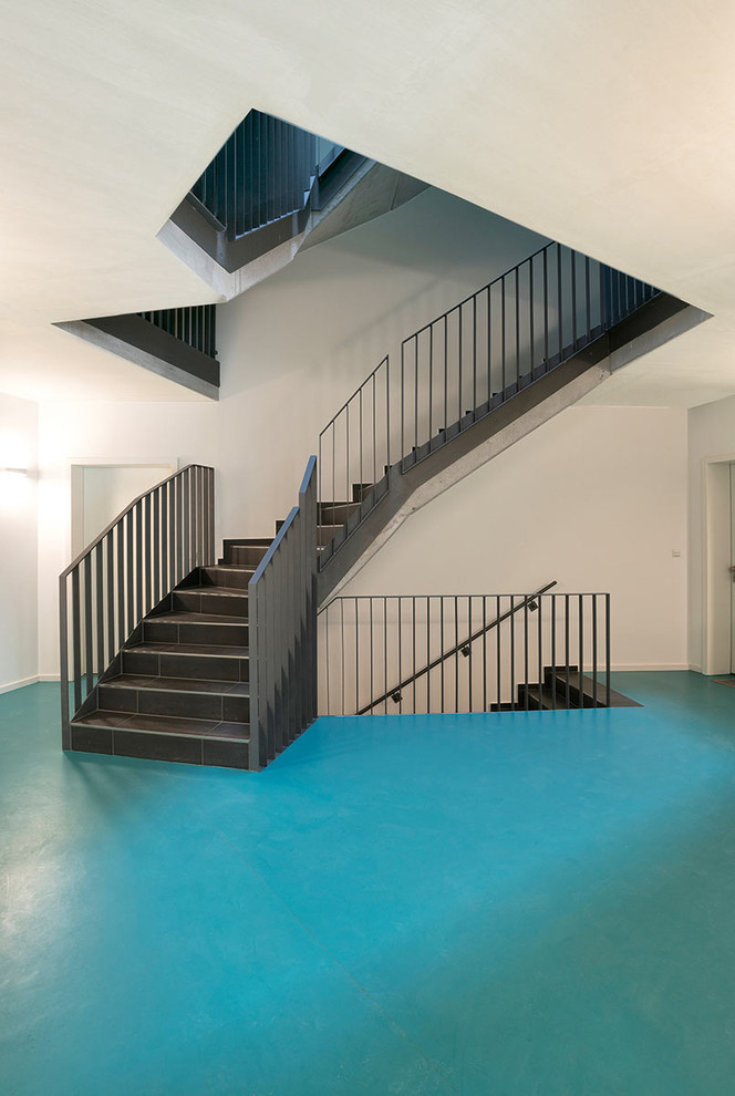 Große Moderne Treppe in U-Form mit Schiefer-Treppenstufen, Schiefer-Setzstufen und Stahlgeländer in Hamburg