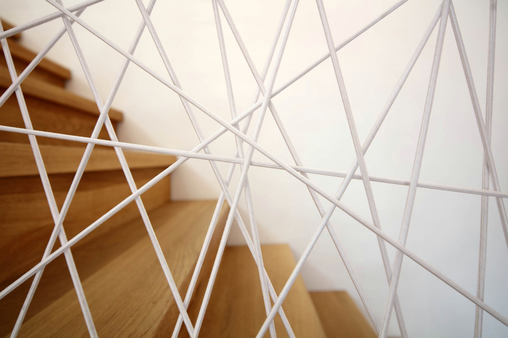 Imagen de escalera recta contemporánea con escalones de madera, contrahuellas de madera y barandilla de metal