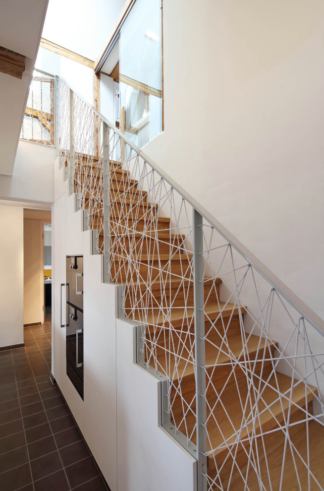 Ejemplo de escalera recta actual con escalones de madera, contrahuellas de madera y barandilla de metal