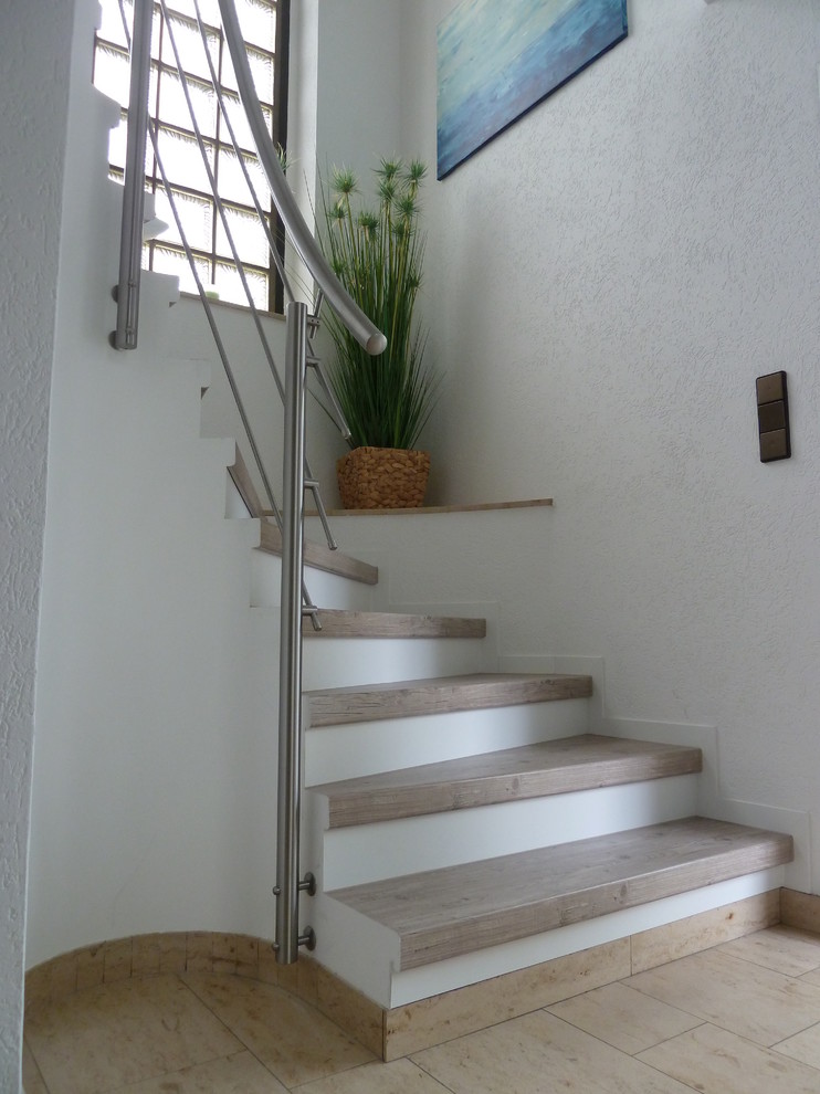 Foto de escalera curva actual de tamaño medio con escalones de hormigón y contrahuellas de hormigón