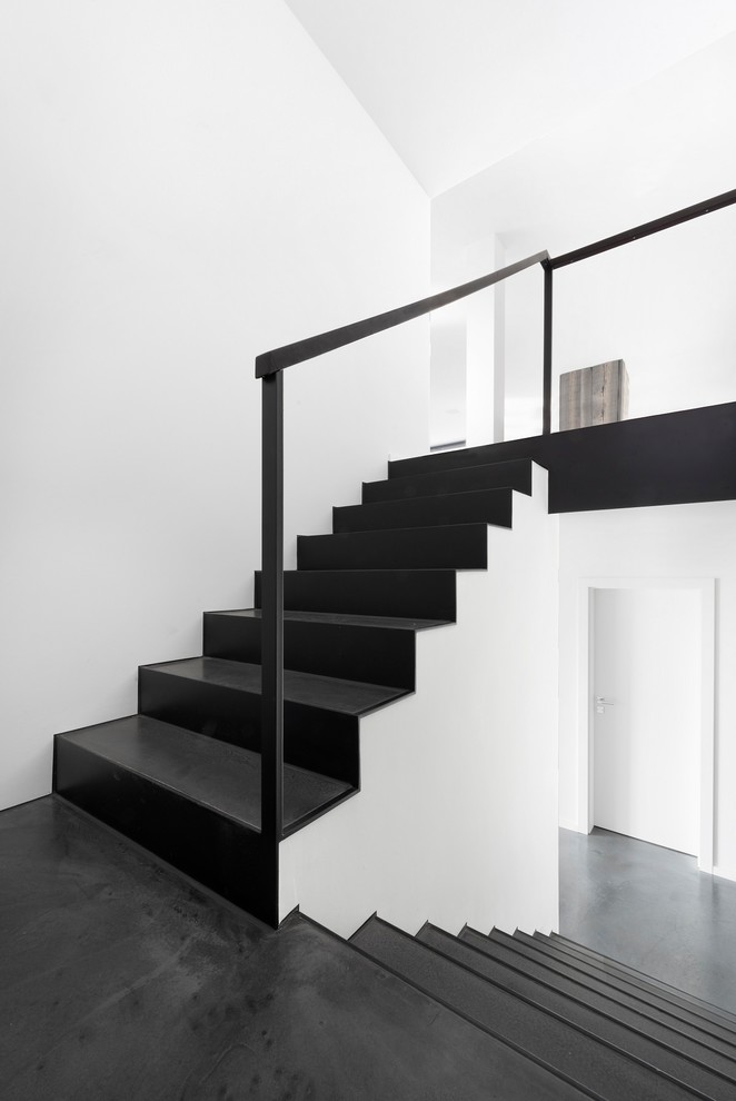 Idée de décoration pour un escalier minimaliste en U avec un garde-corps en métal.