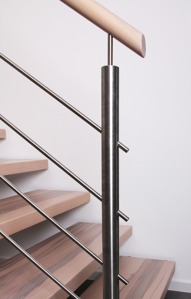 Foto de escalera curva contemporánea de tamaño medio con escalones de madera y barandilla de metal