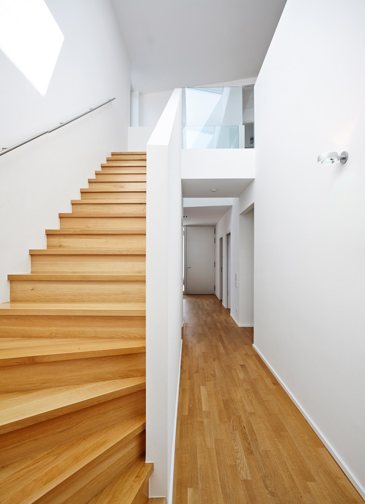 Example of a large trendy wooden curved staircase design in Frankfurt with wooden risers