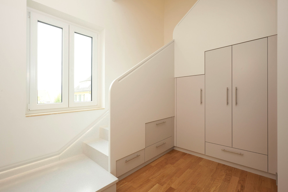 Photo of a medium sized contemporary l-shaped staircase in Other with under stair storage.