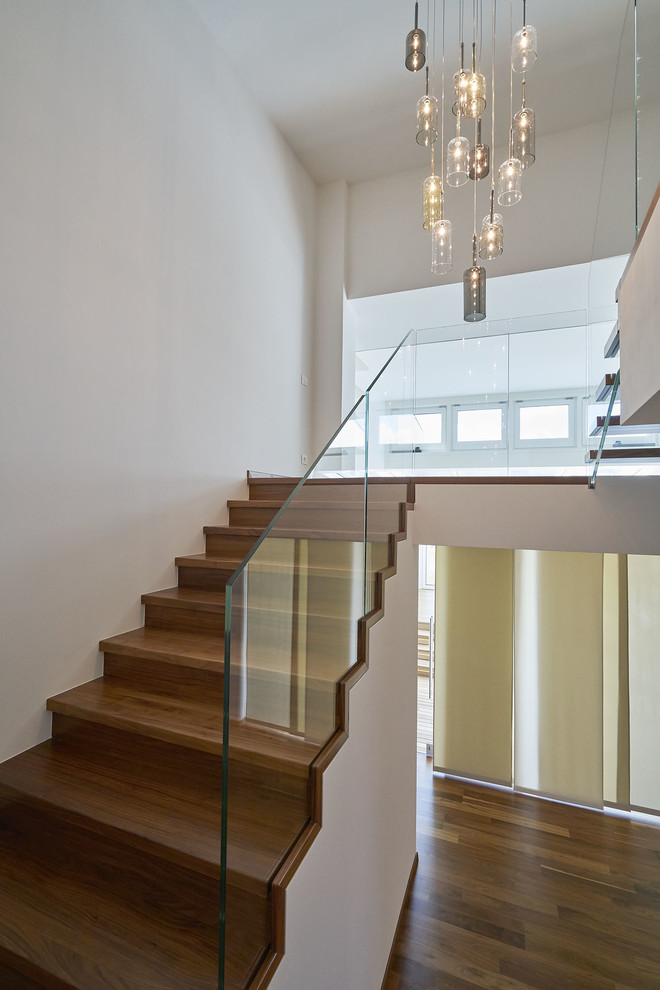 Diseño de escalera en U moderna de tamaño medio con escalones de madera pintada, contrahuellas de madera pintada y barandilla de vidrio
