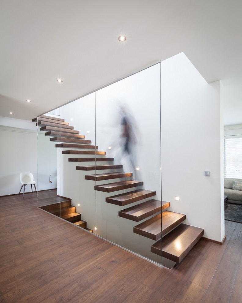 Cette image montre un grand escalier sans contremarche flottant minimaliste avec des marches en bois.