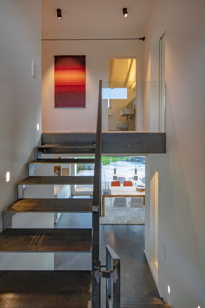 Ejemplo de escalera contemporánea con escalones de metal y barandilla de metal