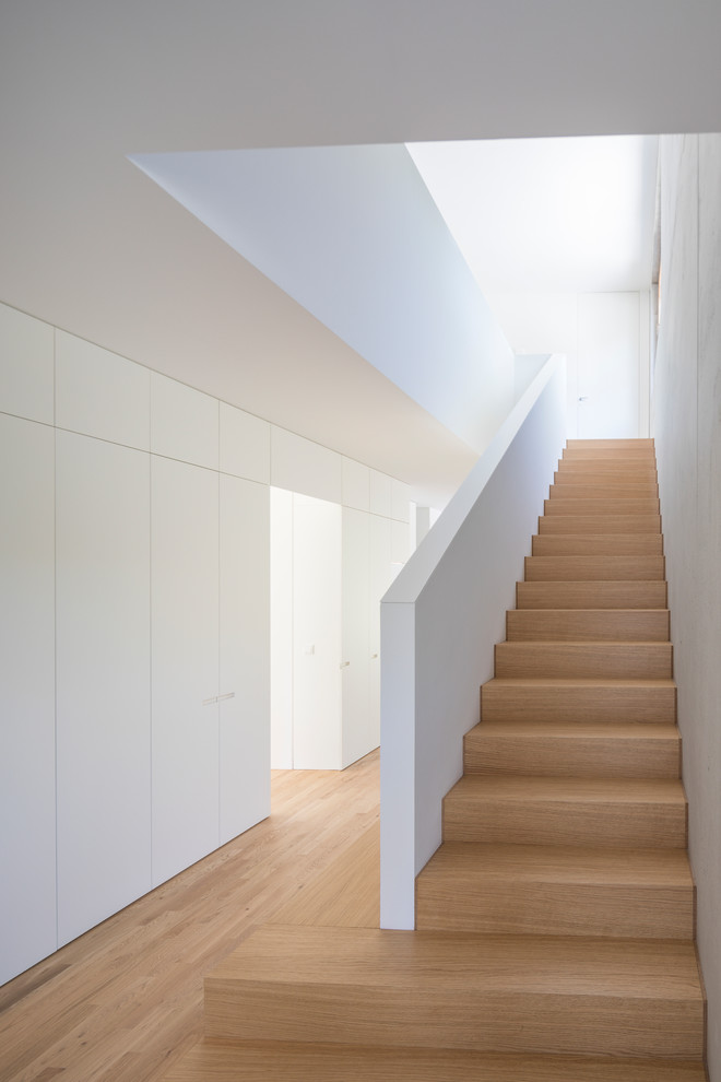 Design ideas for a modern wood staircase in Munich with wood risers.