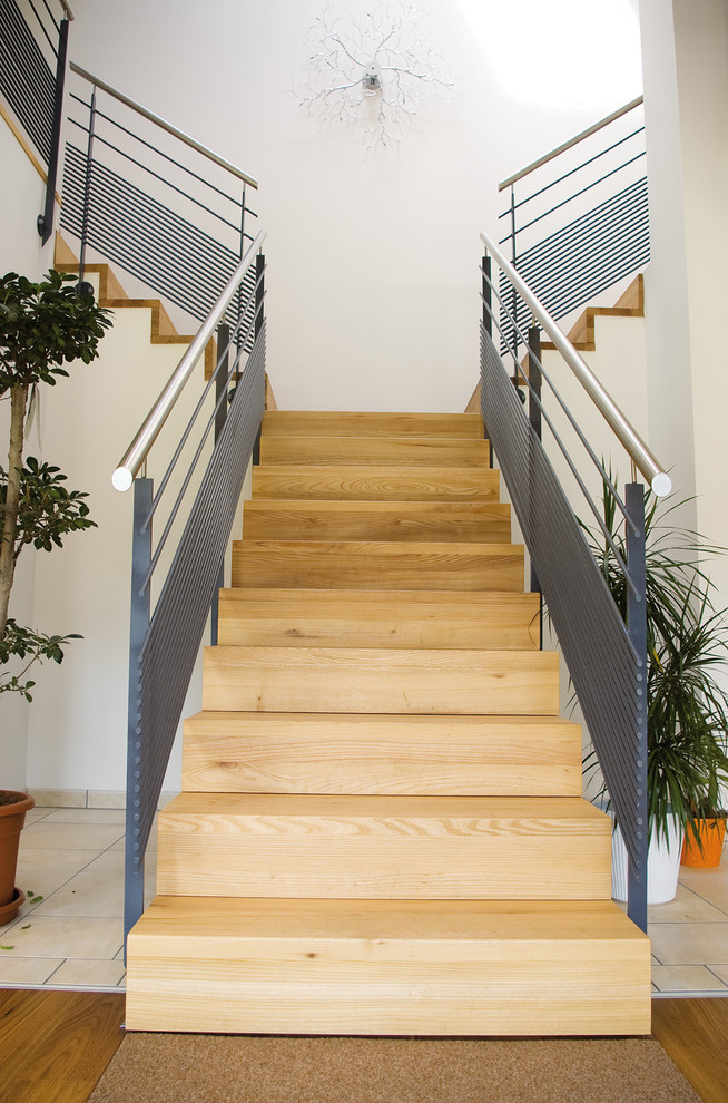 На фото: угловая лестница среднего размера в современном стиле с крашенными деревянными ступенями, крашенными деревянными подступенками и металлическими перилами