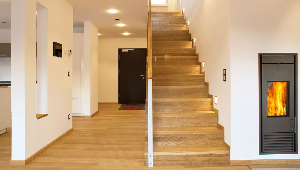 Inspiration pour un escalier droit design de taille moyenne avec des marches en bois, des contremarches en bois et éclairage.