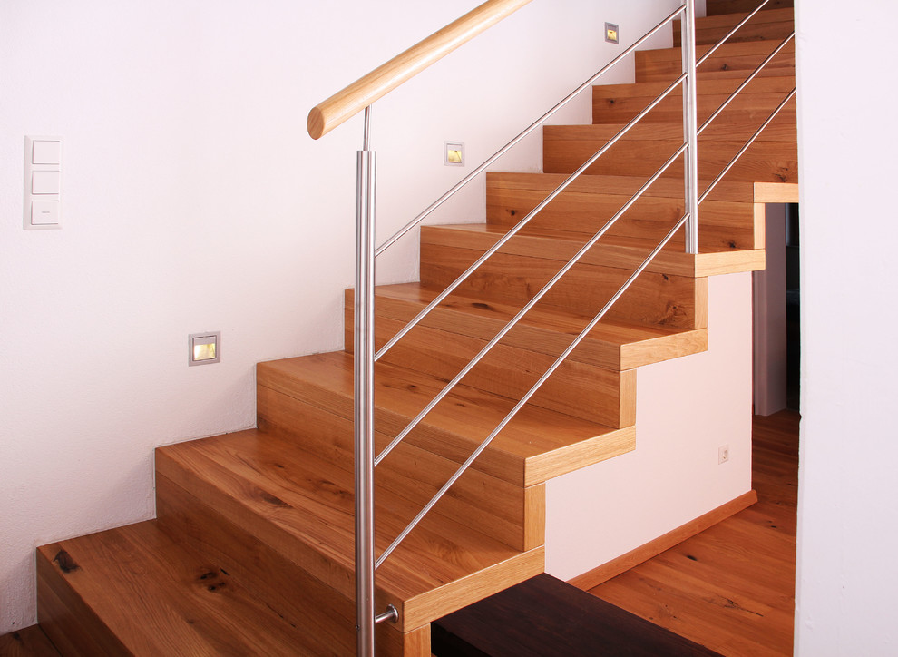Idée de décoration pour un escalier droit design de taille moyenne avec des marches en bois, des contremarches en bois et un garde-corps en métal.