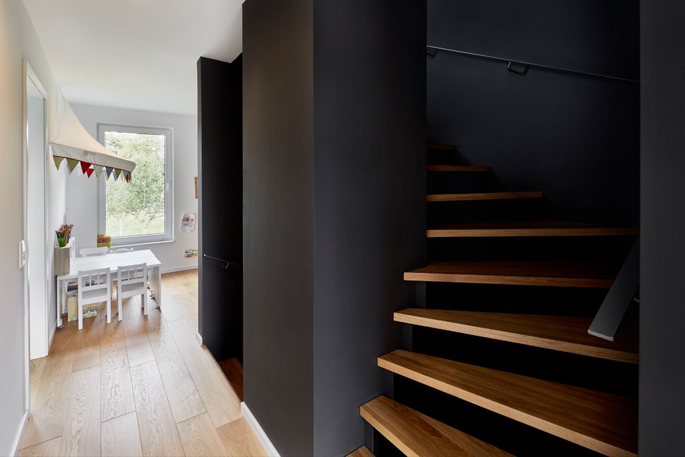 Mittelgroße Moderne Holztreppe in U-Form mit offenen Setzstufen und Stahlgeländer in Essen