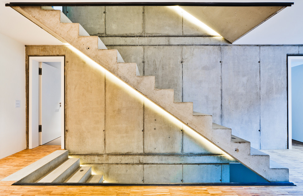 Aménagement d'un grand escalier droit contemporain en béton avec des contremarches en béton.