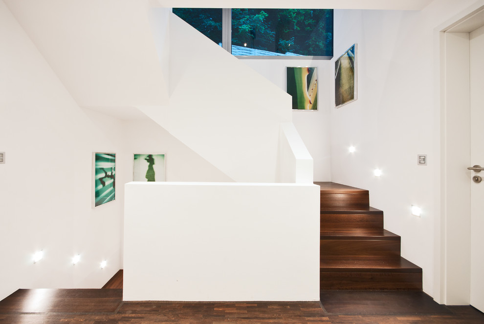 Идея дизайна: большая изогнутая деревянная лестница в современном стиле с деревянными ступенями