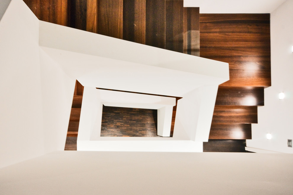 Свежая идея для дизайна: большая изогнутая деревянная лестница в современном стиле с деревянными ступенями - отличное фото интерьера