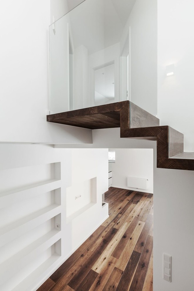 Ejemplo de escalera curva contemporánea con escalones de madera y contrahuellas de madera