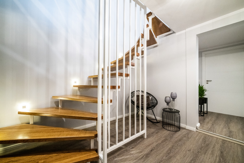 Inspiration for a mid-sized wooden open and metal railing staircase remodel in Hanover