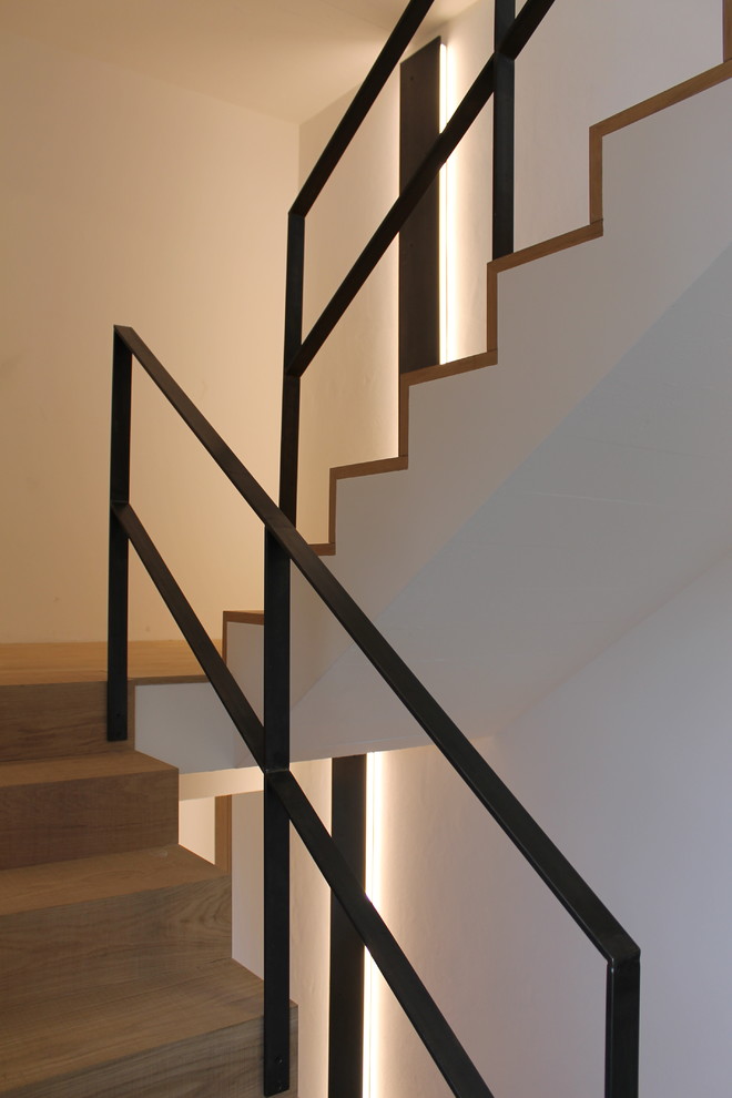 Imagen de escalera en U contemporánea de tamaño medio con escalones de madera pintada, contrahuellas de madera pintada y barandilla de metal