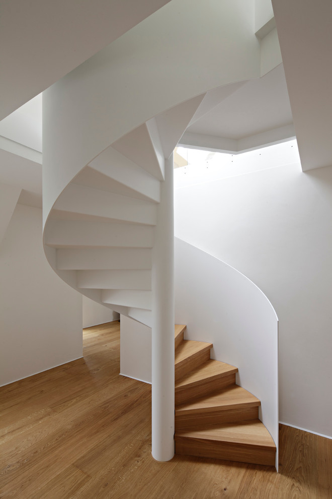На фото: винтовая деревянная лестница в стиле модернизм с деревянными ступенями