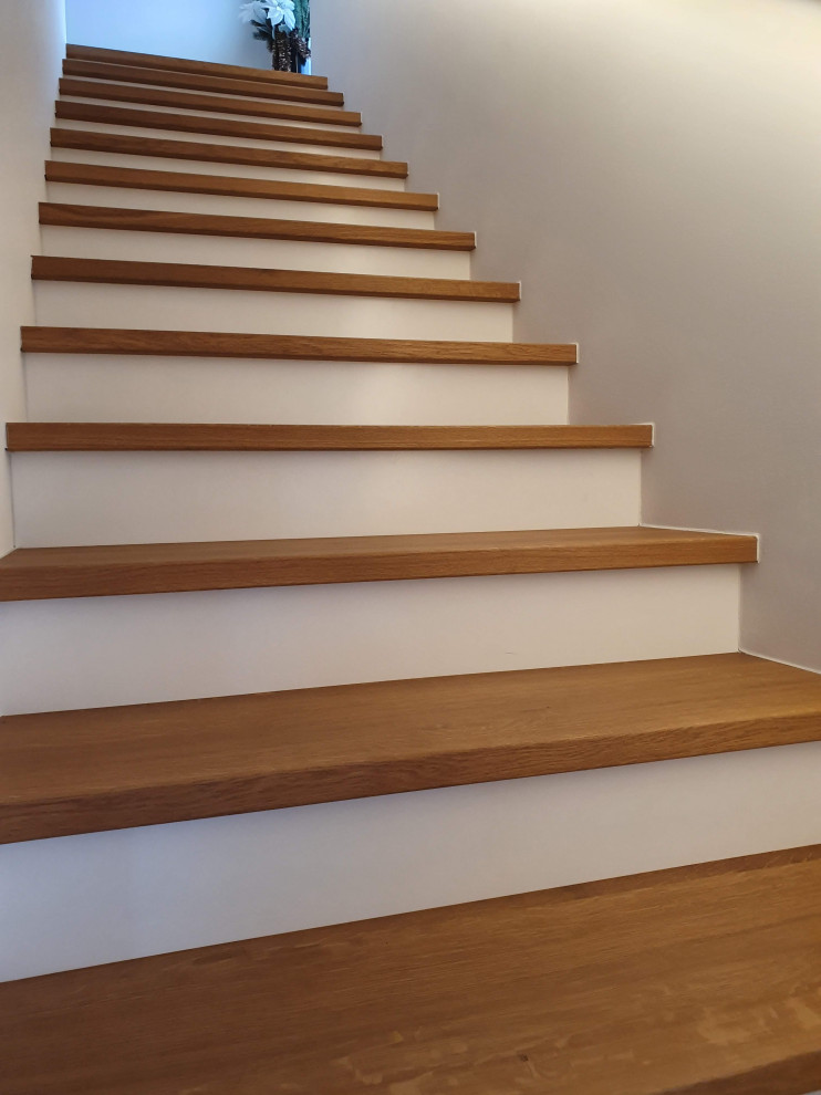 На фото: прямая деревянная лестница среднего размера в современном стиле с деревянными ступенями и деревянными перилами с