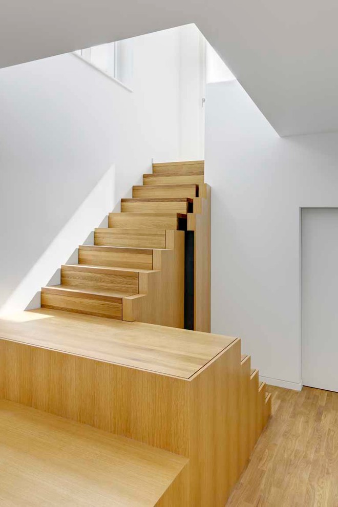 На фото: п-образная деревянная лестница среднего размера в современном стиле с деревянными ступенями и кладовкой или шкафом под ней