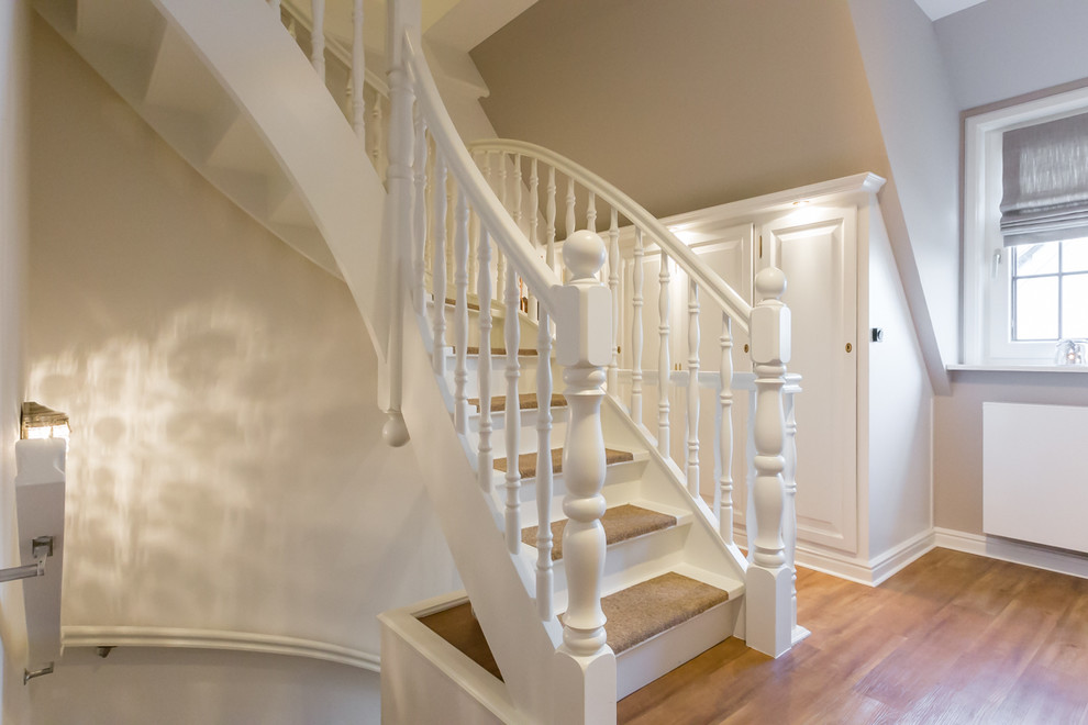 Стильный дизайн: маленькая изогнутая деревянная лестница в классическом стиле с ступенями с ковровым покрытием для на участке и в саду - последний тренд