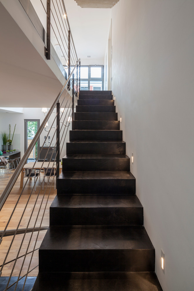 ケルンにあるお手頃価格の中くらいなコンテンポラリースタイルのおしゃれな直階段 (コンクリートの蹴込み板、金属の手すり) の写真