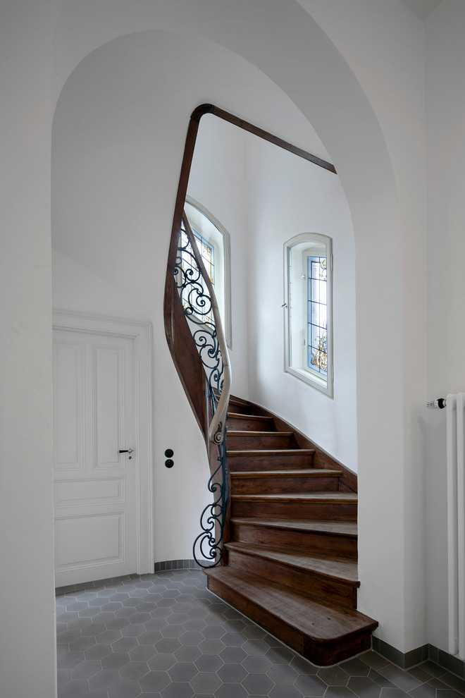 Diseño de escalera curva tradicional de tamaño medio con escalones de madera y contrahuellas de madera