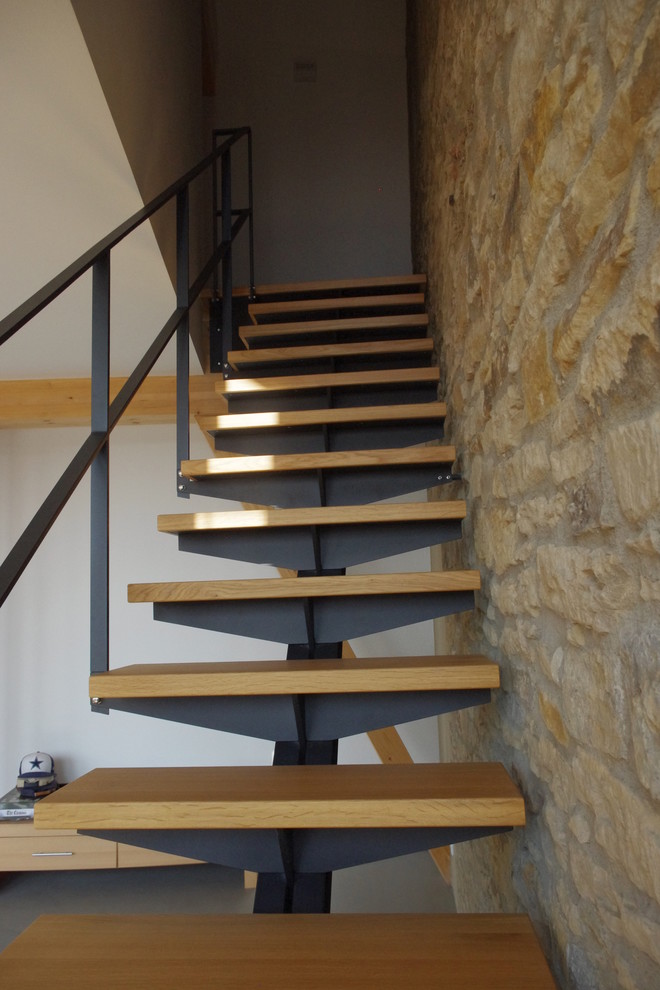 Gerade, Kleine Moderne Treppe mit gebeizten Holz-Treppenstufen, offenen Setzstufen und Stahlgeländer in Leipzig