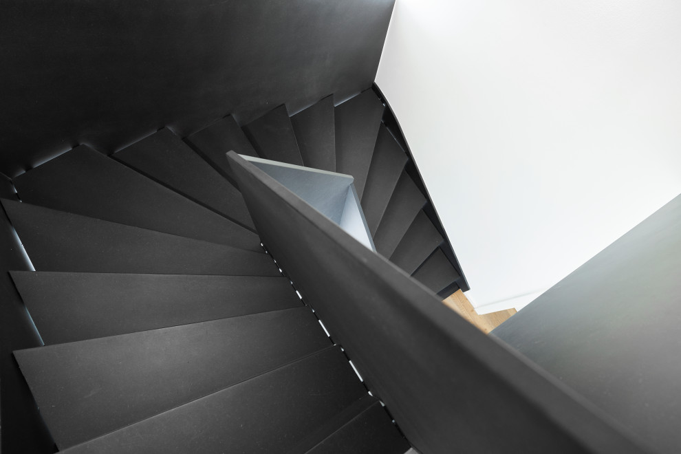フランクフルトにある高級な中くらいなインダストリアルスタイルのおしゃれな折り返し階段 (木の蹴込み板、木材の手すり、壁紙) の写真