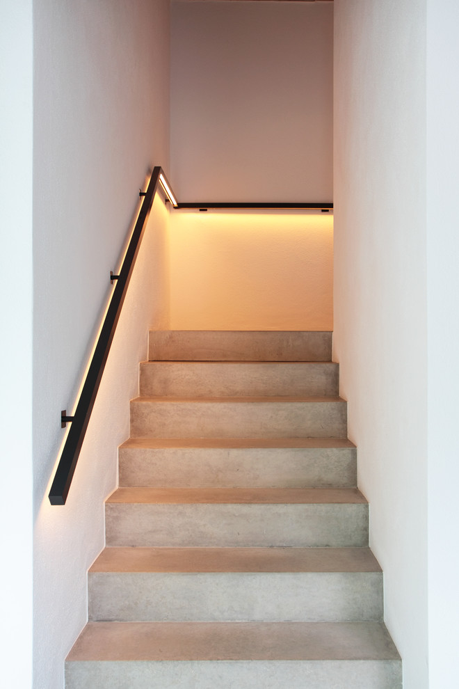 Foto de escalera recta moderna pequeña con escalones de hormigón, contrahuellas de hormigón y barandilla de metal