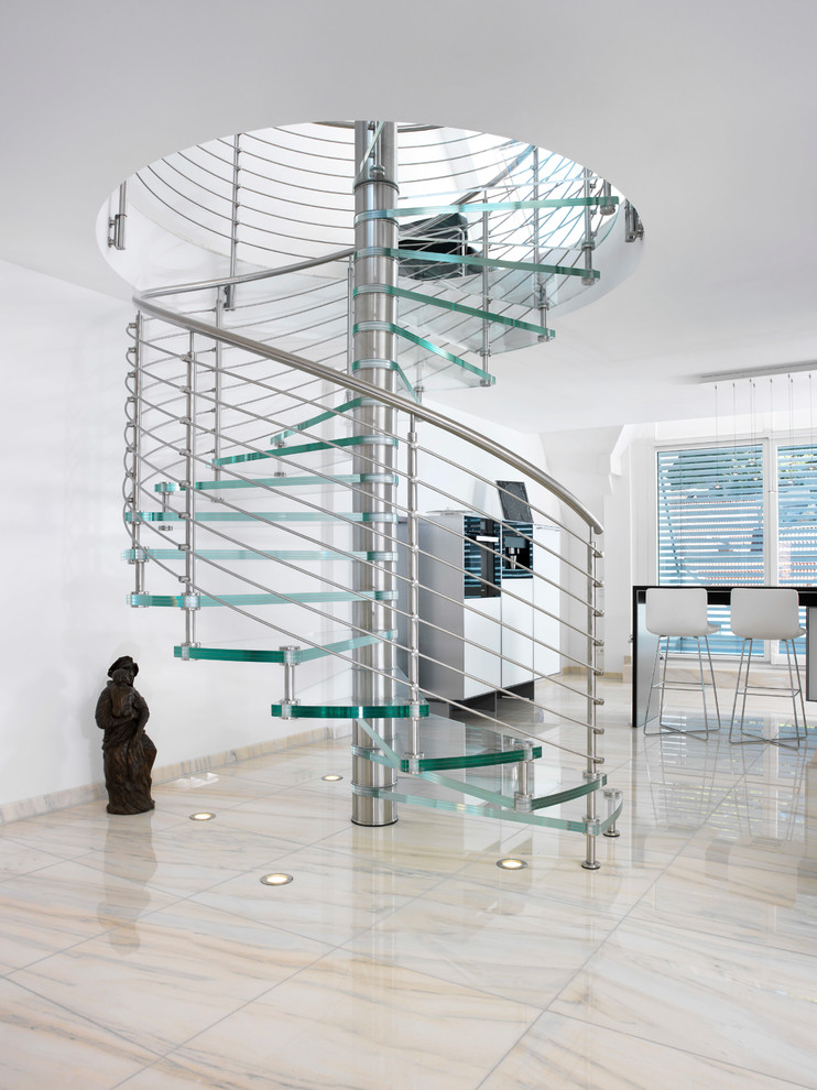 Idées déco pour un grand escalier sans contremarche hélicoïdal contemporain avec des marches en verre et un garde-corps en métal.