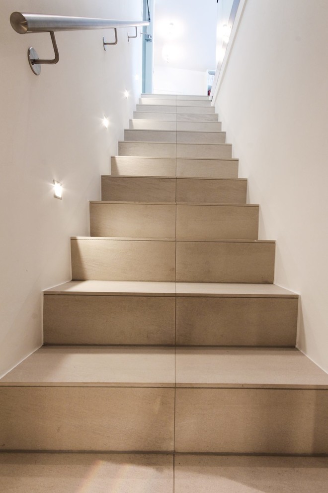 Источник вдохновения для домашнего уюта: огромная прямая лестница в современном стиле с ступенями из плитки, подступенками из плитки и металлическими перилами
