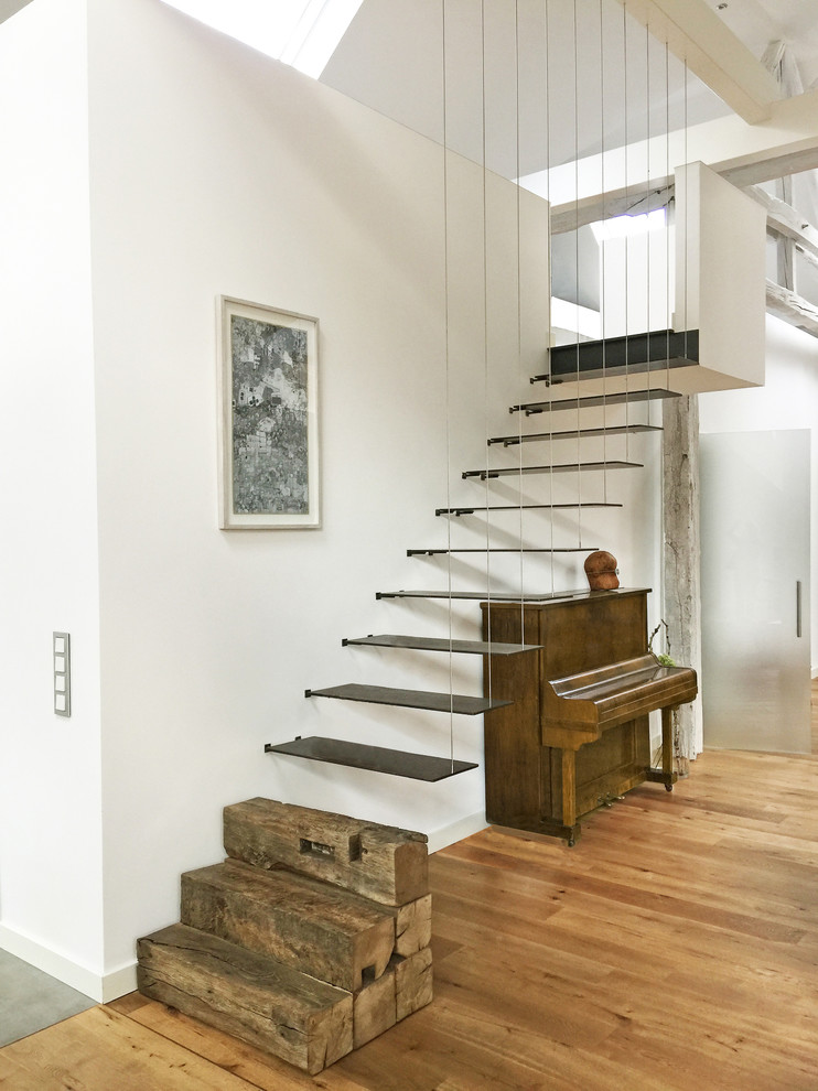 他の地域にある高級な広いコンテンポラリースタイルのおしゃれな階段 (ワイヤーの手すり) の写真