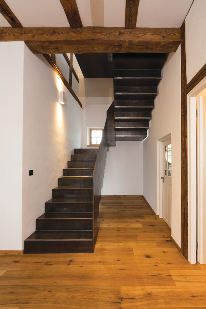 Diseño de escalera curva rústica con escalones de metal y contrahuellas de metal