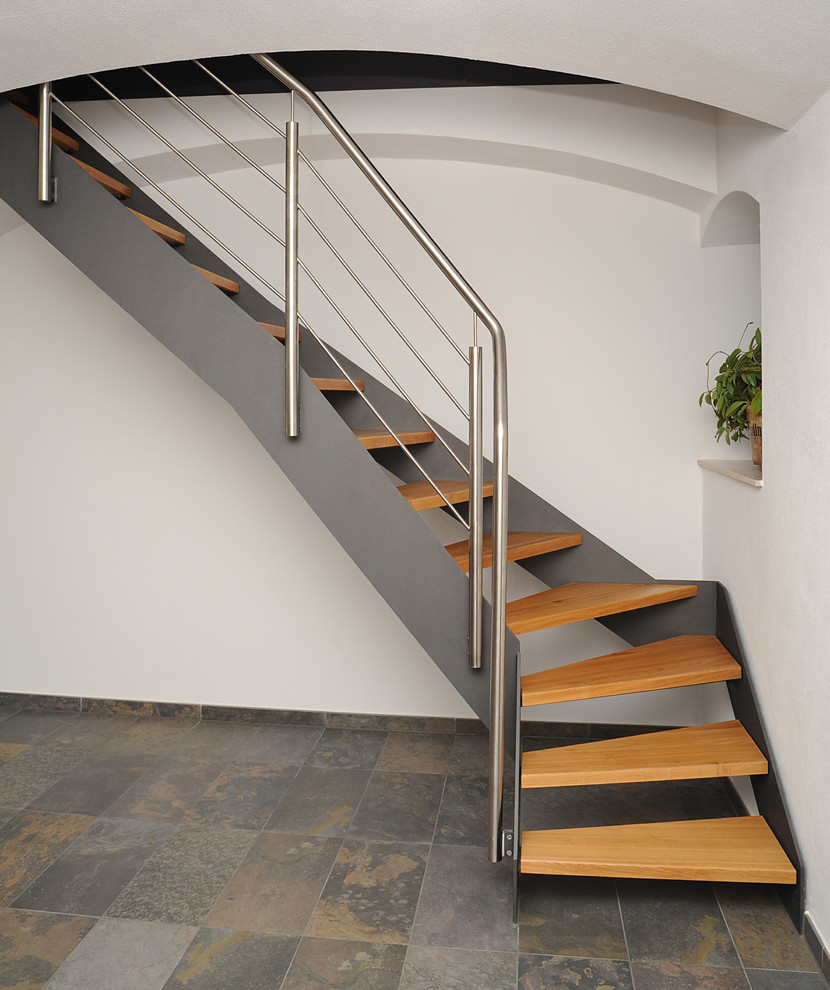 Diseño de escalera curva industrial pequeña sin contrahuella con escalones de madera pintada y barandilla de metal