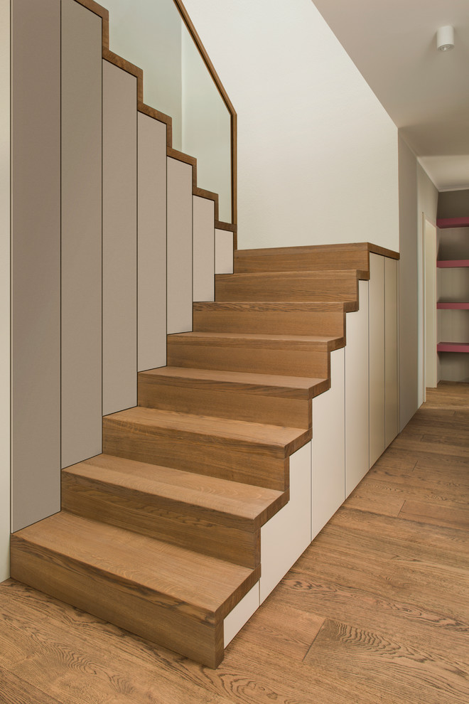 Aménagement d'un grand escalier contemporain en U avec des marches en bois et des contremarches en bois.