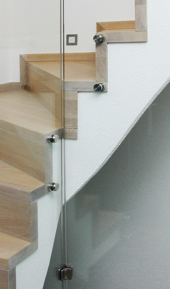 Immagine di una scala curva design di medie dimensioni con alzata in legno e pedata in legno